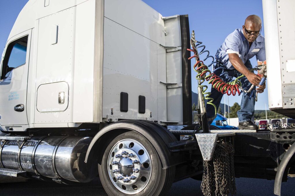 black-man-truck-driver-attaching-power-cables-from-2025-04-04-23-37-15-utc